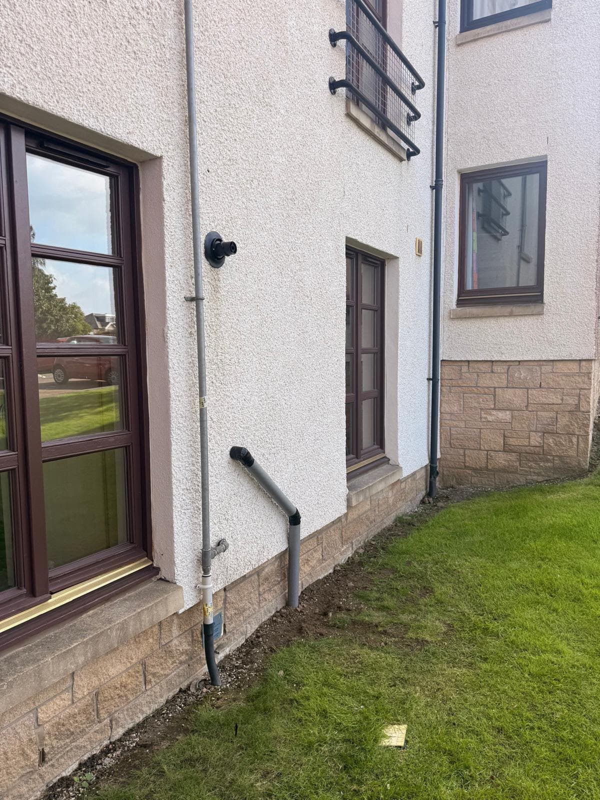 New boiler flue terminal and condensate pipe on the outside wall of a house in Livingston