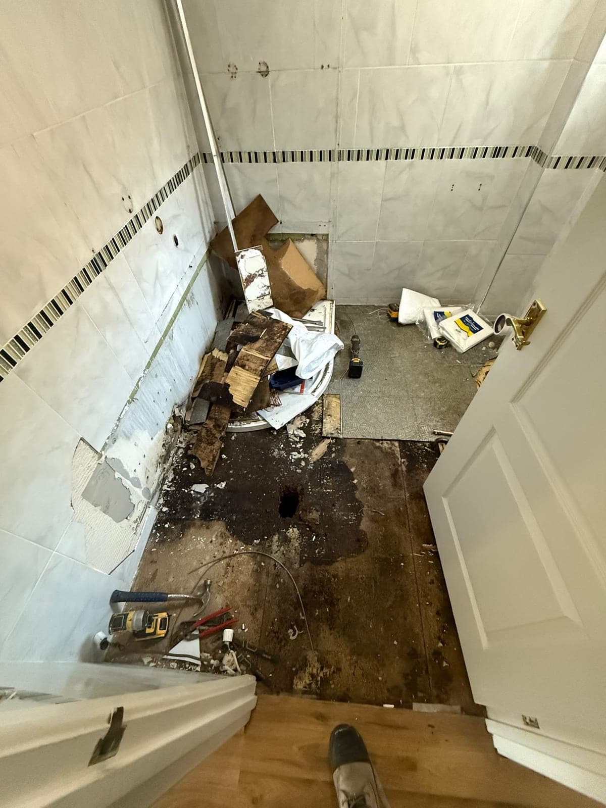 Edinburgh shower room stripped back to bare floor before refitting, with old tiles and tray removed