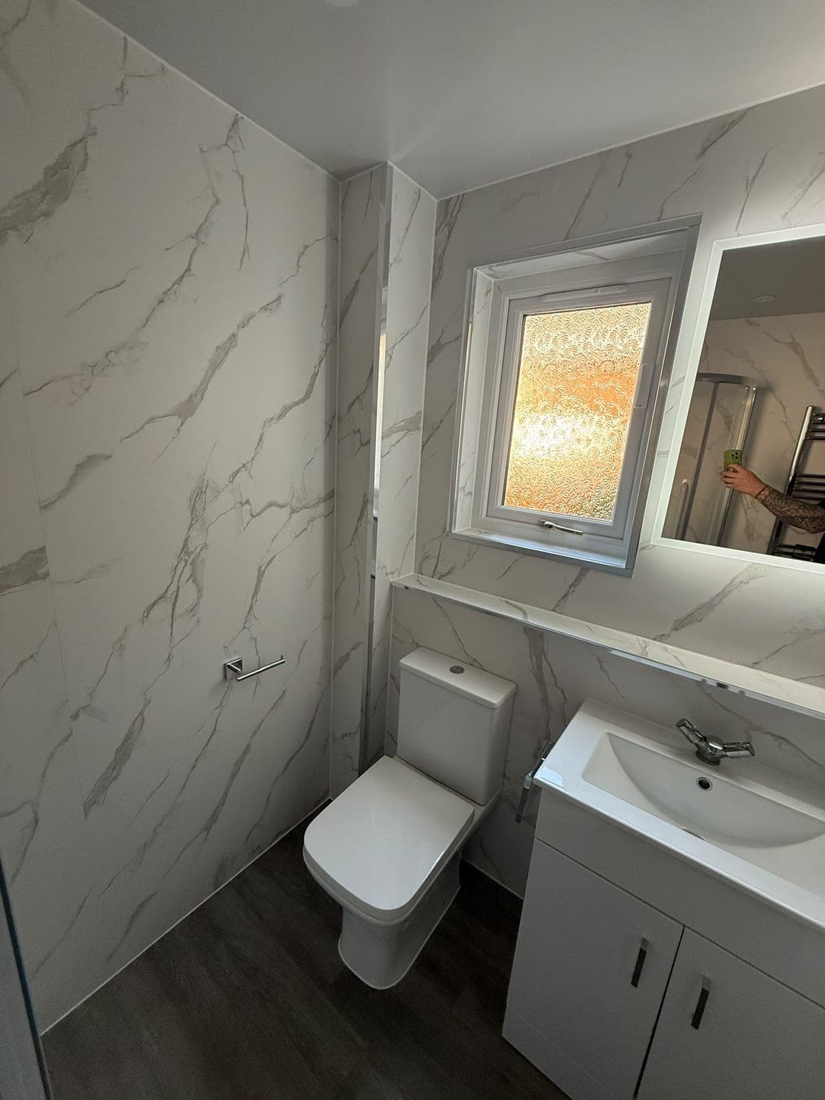 Marble-effect wall panels, close-coupled WC and vanity basin in an Edinburgh easy-access shower room