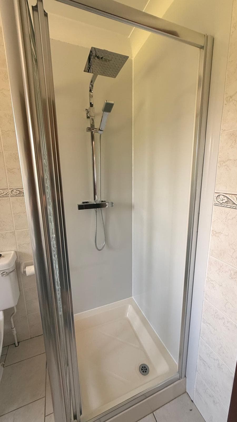 Replaced shower cubicle with white wall panels, thermostatic rainfall shower and a chrome framed door, Kirkcaldy